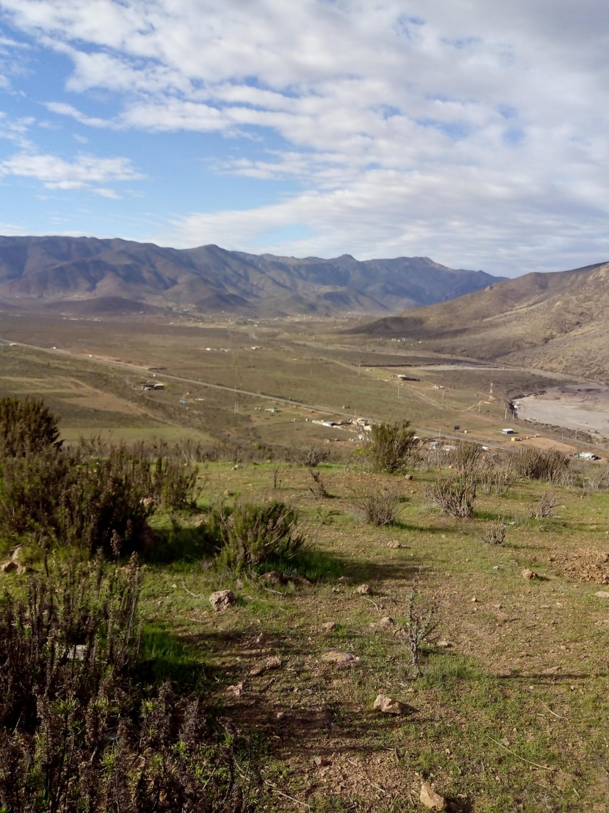 Paisaje abierto con vegetación, cerros y nubes en Cuesta El Manzano